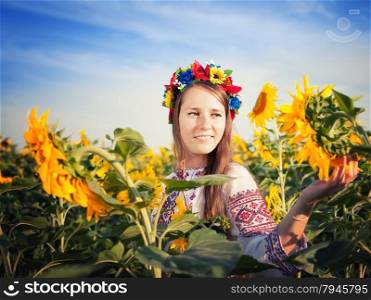 Beautiful young woman at sunflower field. Ukrainian woman
