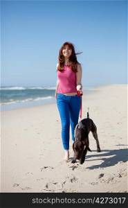 Beautiful young woman at the beach with a dog