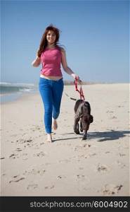 Beautiful young woman at the beach with a dog