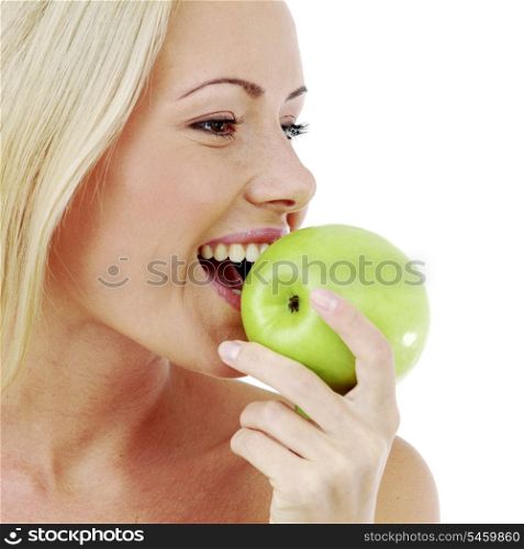 Beautiful young woman bites a green apple, isolated on white