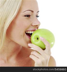 Beautiful young woman bites a green apple, isolated on white