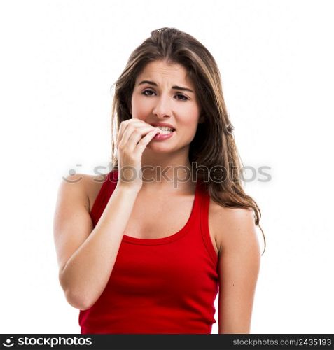 Beautiful young woman biting her nails, isolated over a white background