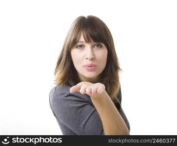 Beautiful young woman blowing a kiss, isolated on a white background