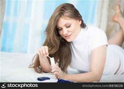 Beautiful Young Woman Checking Blood Sugar Level by Glucose Meter at Home. Medicine, Diabetes, Glycemia, Health Care Concept