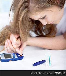 Beautiful Young Woman Checking Blood Sugar Level by Glucose Meter at Home. Medicine, Diabetes, Glycemia, Health Care Concept