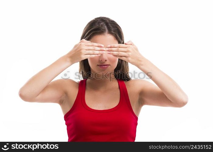 Beautiful young woman covering both eyes with her hands, isolated over a white background