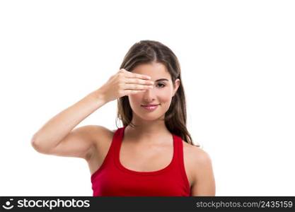 Beautiful young woman covering one eye with her hand, isolated over a white background