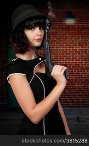 Beautiful young woman criminal with a gun
