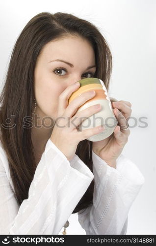 Beautiful young woman drinking from a coffee mug.