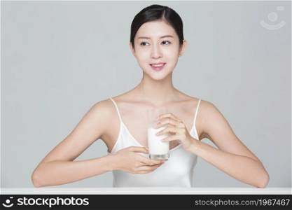 Beautiful young woman drinking milk