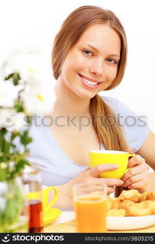 Beautiful young woman drinking tea from yellow cup