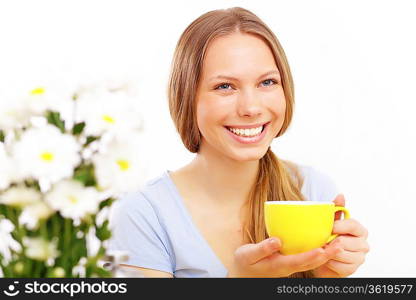 Beautiful young woman drinking tea from yellow cup