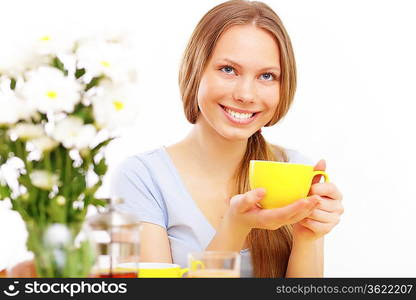 Beautiful young woman drinking tea from yellow cup