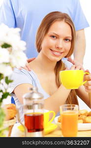 Beautiful young woman drinking tea from yellow cup