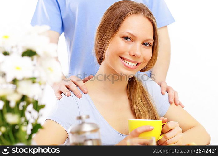 Beautiful young woman drinking tea from yellow cup