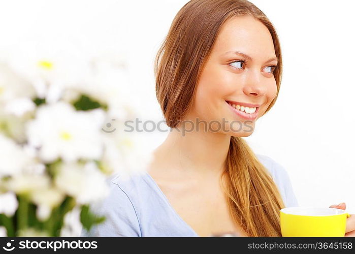 Beautiful young woman drinking tea from yellow cup