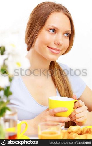 Beautiful young woman drinking tea from yellow cup