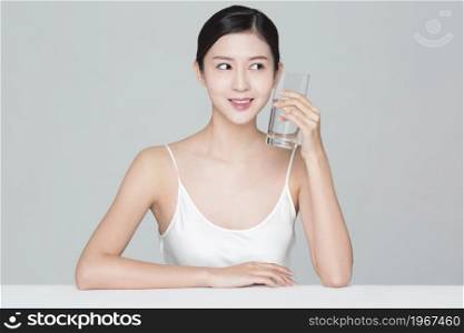 Beautiful young woman drinking water