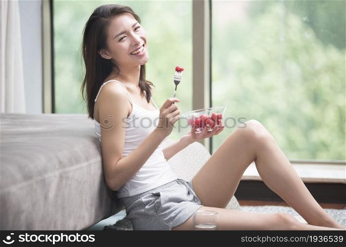 Beautiful young woman eating fruit