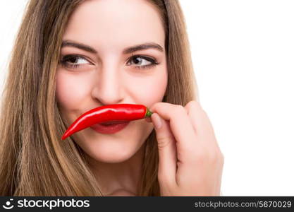 Beautiful young woman eating pepper over white