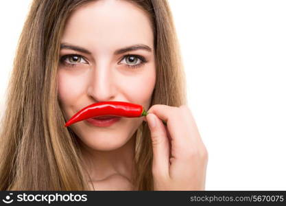 Beautiful young woman eating pepper over white