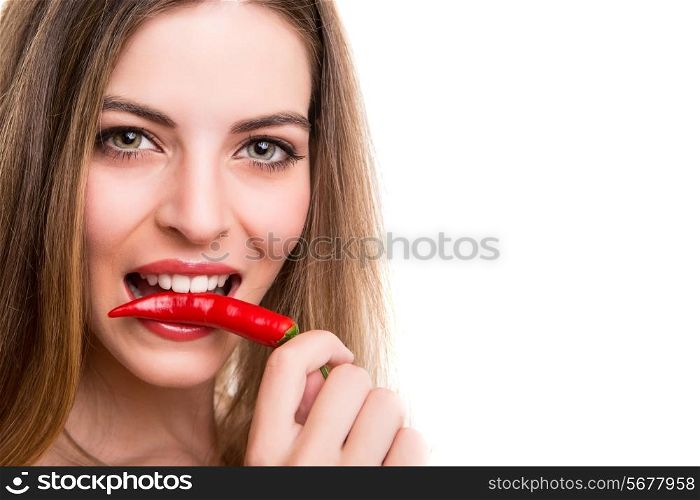 Beautiful young woman eating pepper over white