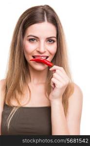 Beautiful young woman eating pepper over white