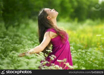Beautiful young woman enjoying freedom on flower field