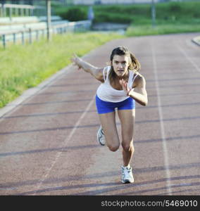 beautiful young woman exercise jogging and runing on athletic track on stadium at sunrise