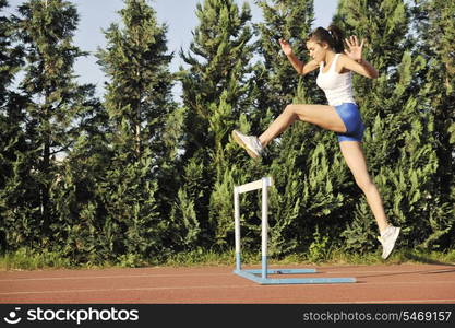 beautiful young woman exercise jogging and runing on athletic track on stadium at sunrise