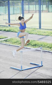 beautiful young woman exercise jogging and runing on athletic track on stadium at sunrise