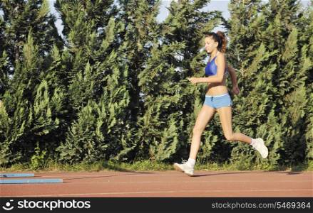 beautiful young woman exercise jogging and runing on athletic track on stadium at sunrise