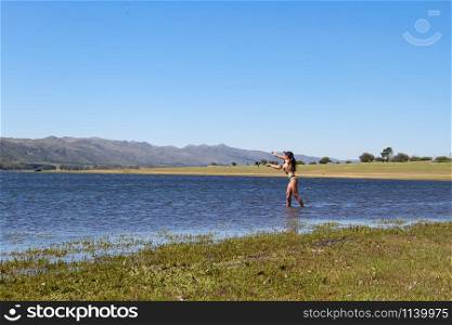 beautiful young woman fishing the mountain lake
