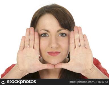 Beautiful young woman framing face with hands. Shot in studio over white.