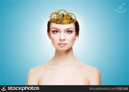 Beautiful young woman (girl) head is open the brain is replaced withmechanism. Bare shoulders. Photograph on a blue background