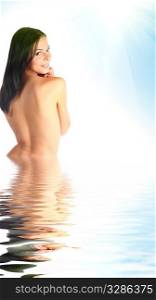 Beautiful young woman half in water against blue sky and sun light
