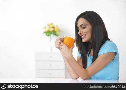 Beautiful young woman having coffee at home