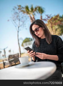 Beautiful young woman having Zoom video conference call via smart phone. Zoom Call Meeting. During Covid-19 Coronavirus pandemic