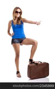 Beautiful young woman hitch hiking with old leather suitcase, isolated on white
