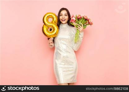 Beautiful young woman hold bouquet of tulips flowers and balloon number 8, rejoices spring holiday. Women’s Day on March 8th