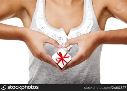 Beautiful young woman holding a gift in front of her heart, isolated on white