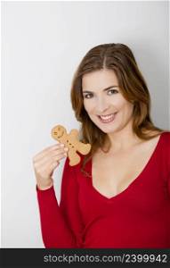 Beautiful young woman holding a gingerbread cookie