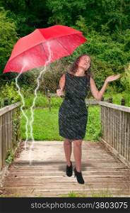 Beautiful young woman holding an umbrella in the rain