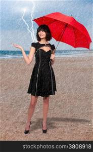 Beautiful young woman holding an umbrella in the rain