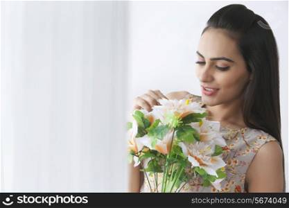 Beautiful young woman holding bunch of flowers