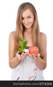 Beautiful young woman holding green sprout of tree and apple