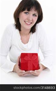 Beautiful young woman holding red gift box. Over white.