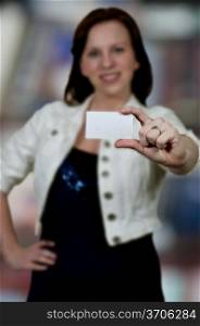Beautiful young woman holding up a business card
