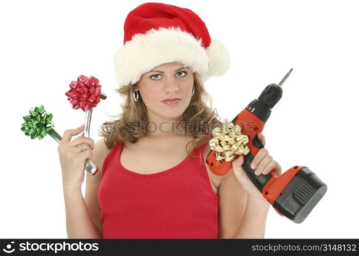 Beautiful young woman holding up tools with bows on them. Wearing santa hat and red tank top. Shot over white.
