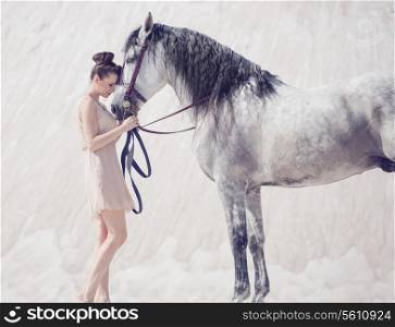 Beautiful young woman hugging the arabian horse